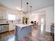 Open concept kitchen with a center island, stainless steel appliances, and hardwood floors overlooking the dining area at 5121 Arbordale Way, Mount Holly, NC 28120