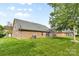 A well-maintained lawn and brick home with large windows, an air conditioner, and a grey roof at 5707 Sustar Dr, Monroe, NC 28110