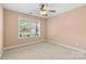 Cozy bedroom with neutral carpet, ceiling fan, and natural light from a large window at 5707 Sustar Dr, Monroe, NC 28110