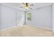 A bedroom with carpet, a window, a ceiling fan and a double door closet with white trim at 5707 Sustar Dr, Monroe, NC 28110