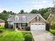 Charming brick home with well-manicured lawn, dormer windows, and a two-car garage at 5707 Sustar Dr, Monroe, NC 28110
