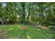 A fenced backyard featuring a brick fire pit and surrounded by lush trees at 6215 Cross Creek Ln, Charlotte, NC 28212