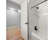 Bathroom with tub, shower, and bright light, with open doorway to hardwood floor at 6215 Cross Creek Ln, Charlotte, NC 28212
