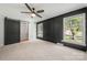 Inviting bedroom with black accent wall, a ceiling fan, and natural light from the bright windows at 6215 Cross Creek Ln, Charlotte, NC 28212