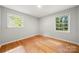 Comfortable bedroom with hardwood floors and bright natural light from the updated double-hung windows at 6215 Cross Creek Ln, Charlotte, NC 28212