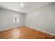 Neutral bedroom with hardwood floors, bright windows, and neutral paint at 6215 Cross Creek Ln, Charlotte, NC 28212