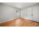 Sunny bedroom features hardwood floors, neutral paint, and a bright window next to the closet at 6215 Cross Creek Ln, Charlotte, NC 28212