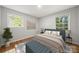 Staged bedroom showcases hardwood floors, neutral decor and two large windows at 6215 Cross Creek Ln, Charlotte, NC 28212