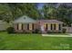 Charming brick home with a well-manicured lawn and an American flag waving in the breeze at 6215 Cross Creek Ln, Charlotte, NC 28212