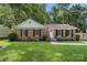 Charming brick home featuring a well-manicured lawn, black shutters, and an American flag at 6215 Cross Creek Ln, Charlotte, NC 28212
