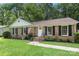 Charming brick home featuring a well-manicured lawn, black shutters, and an American flag at 6215 Cross Creek Ln, Charlotte, NC 28212