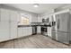 The kitchen has stainless appliances, lots of white cabinets, and wood grain flooring at 6215 Cross Creek Ln, Charlotte, NC 28212