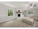 Bright living room with large windows, painted brick fireplace, and carpeted flooring at 6215 Cross Creek Ln, Charlotte, NC 28212