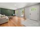 Bright living room featuring wood floors, a modern sofa, and ample natural light at 6215 Cross Creek Ln, Charlotte, NC 28212