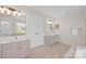 Bright bathroom features double sinks, tiled floors, and large soaking tub at 6803 Augustine Way, Charlotte, NC 28270