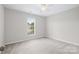Neutral bedroom with a ceiling fan and a large window at 6803 Augustine Way, Charlotte, NC 28270