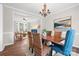 Chic dining room showcases wood table, wicker chairs, and chandelier, seamlessly connected to a bright living area at 6803 Augustine Way, Charlotte, NC 28270