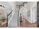 Inviting two-story entryway featuring a staircase with black and white railings, hardwood floors and neutral walls at 6803 Augustine Way, Charlotte, NC 28270