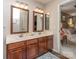 Beautifully designed bathroom with a double vanity, cherry wood cabinets, and elegant mirrors at 7700 Antique Cir, Waxhaw, NC 28173