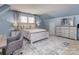 Comfortable bedroom with a gray desk, two windows, and a stylishly decorated queen-sized bed at 7700 Antique Cir, Waxhaw, NC 28173