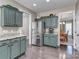 Well-lit kitchen with green cabinets, granite countertops, stainless steel appliances, and dark floors at 7700 Antique Cir, Waxhaw, NC 28173
