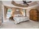 Inviting primary bedroom boasts a tray ceiling, two windows, and a plush queen-sized bed at 7700 Antique Cir, Waxhaw, NC 28173