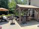 Outdoor kitchen with grill, smoker, pizza oven and comfortable seating and a sun umbrella at 7700 Antique Cir, Waxhaw, NC 28173