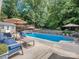 Backyard pool with cozy lounge seating, a pool house, and beautiful landscaping at 7700 Antique Cir, Waxhaw, NC 28173