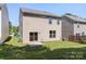 View of the back of the house, showing a patio, a sliding door, and green grass at 858 Rook Rd, Charlotte, NC 28216