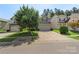Charming home with a well-maintained lawn, driveway, and a large tree in the front yard at 858 Rook Rd, Charlotte, NC 28216