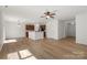 Open-concept living room with wood-look flooring, ceiling fan and kitchen bar at 858 Rook Rd, Charlotte, NC 28216