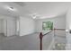Bright loft area featuring neutral carpeting, a ceiling fan, and a window view for natural lighting at 858 Rook Rd, Charlotte, NC 28216