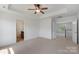 Main bedroom with neutral carpet, tray ceiling with overhead ceiling fan, and an ensuite bathroom at 858 Rook Rd, Charlotte, NC 28216