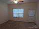Neutral bedroom with carpet, a window with blinds, ceiling fan, and access to the outside at 8838 Wandering Creek Way, Charlotte, NC 28227