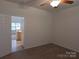 Carpeted bedroom with an open door leading to the kitchen area and natural light at 8838 Wandering Creek Way, Charlotte, NC 28227