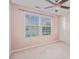 Bright bedroom features two windows with blinds, ceiling fan, neutral carpet, and light peach walls at 9001 Lanark Ln, Fort Mill, SC 29707