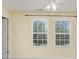 Bedroom offers natural light from two large windows, ceiling fan, and pale yellow walls at 9001 Lanark Ln, Fort Mill, SC 29707