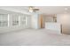 Bright bonus room features neutral carpet, a ceiling fan, and abundant natural light from large windows at 9001 Lanark Ln, Fort Mill, SC 29707