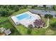 Aerial view of the community pool with a spacious deck, lounge chairs and clubhouse at 9001 Lanark Ln, Fort Mill, SC 29707