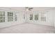 Open room with white walls, a ceiling fan, neutral carpet, and three windows providing lots of light at 9001 Lanark Ln, Fort Mill, SC 29707