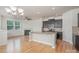 Bright open-concept kitchen with hardwood floors, granite countertops, and stainless steel microwave at 9001 Lanark Ln, Fort Mill, SC 29707