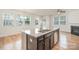 Spacious kitchen with a large island, stainless steel dishwasher, and a view of the fireplace at 9001 Lanark Ln, Fort Mill, SC 29707
