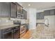 Close-up of the kitchen featuring granite countertops, stainless steel appliances, and dark wood cabinets at 9001 Lanark Ln, Fort Mill, SC 29707