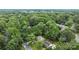 An aerial view shows a home surrounded by lush green trees and landscaping at 906 Wishing Well Ln, Charlotte, NC 28270