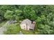 Aerial view of a home with a large yard, patio, and mature trees at 906 Wishing Well Ln, Charlotte, NC 28270