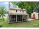 Rear view of a home with a screened-in porch, shed, and a spacious backyard at 906 Wishing Well Ln, Charlotte, NC 28270