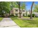 Traditional home with green shutters and a well-maintained lawn, complemented by mature trees and an ample driveway at 906 Wishing Well Ln, Charlotte, NC 28270