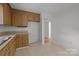 Neutral kitchen with wood cabinets, tile flooring, and access to another room at 906 Wishing Well Ln, Charlotte, NC 28270