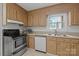 Traditional kitchen featuring wood cabinets, stainless steel appliances, and a window over the sink at 906 Wishing Well Ln, Charlotte, NC 28270