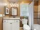 Traditional bathroom with vanity, framed mirror, neutral shower tile, and natural light at 9908 Park Springs Ct, Charlotte, NC 28210